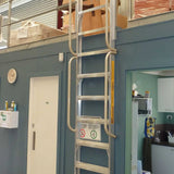 mezzalad ladder resting flat against a blue wall with a door and kitchen area in the background